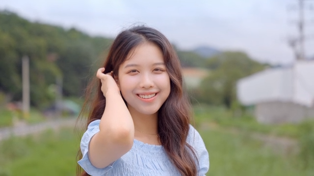 초원에서 미소 짓는 젊은 여성