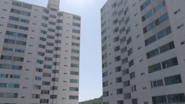 Tall apartment buildings under a bright sun