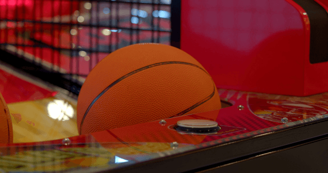 Person playing a basketball arcade game in an arcade