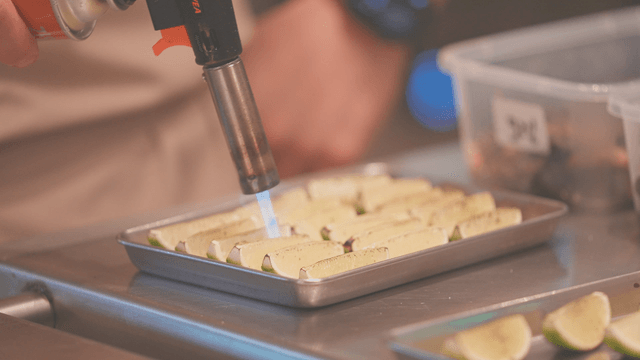 Cooking lime slices with a torch in kitchen