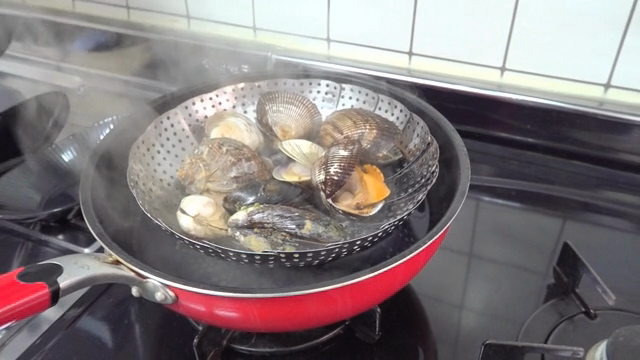 Steaming shellfish in a red pan