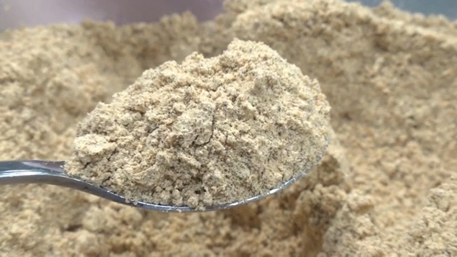 Shiitake mushroom powder being scooped with a spoon