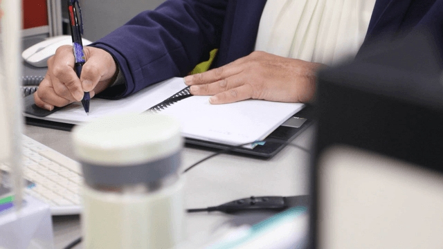 Person writing notes at a desk