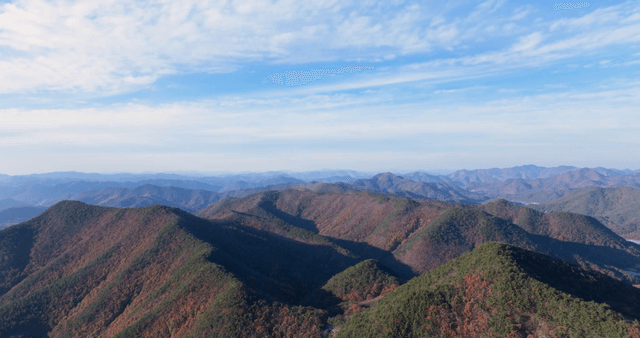 Expansive autumn mountain range under a clear sky