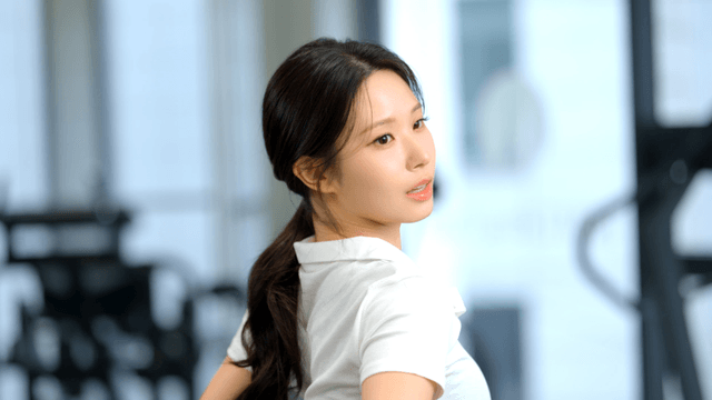 Young woman stretching her lower back at gym