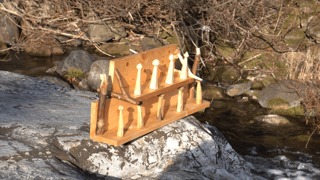 Wooden shelf on gray rocks beside a valley