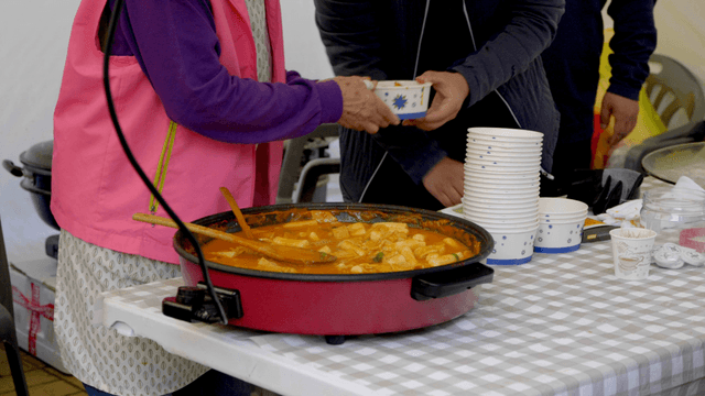 음식 가판대에서 나누어 담아지는 떡볶이