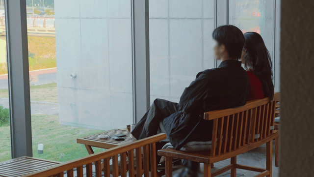 Couple sitting by a large window