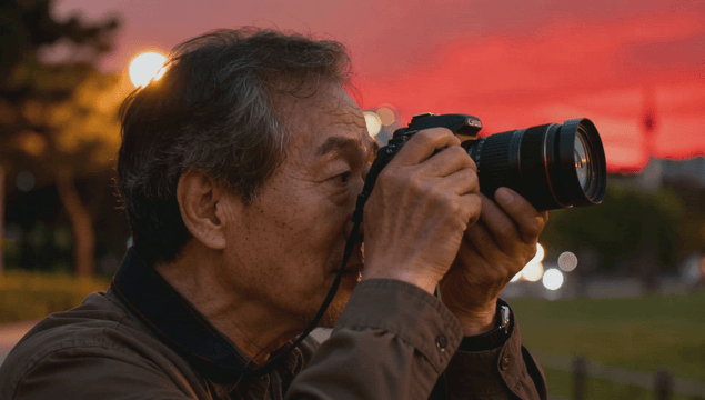 Elder photographer shooting at sunset park