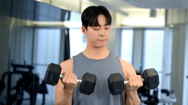 Man lifting dumbbells in a gym