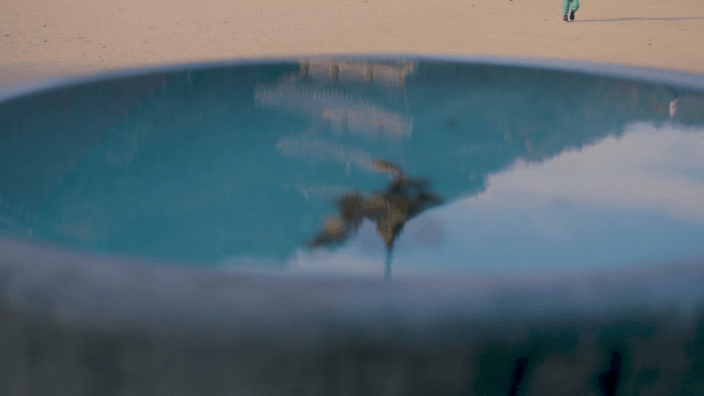 Walking family and temple roof near a shallow puddle