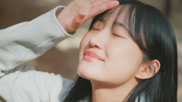 Smiling woman enjoying sunlight