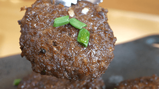 Grilled short rib patty garnished with green onion