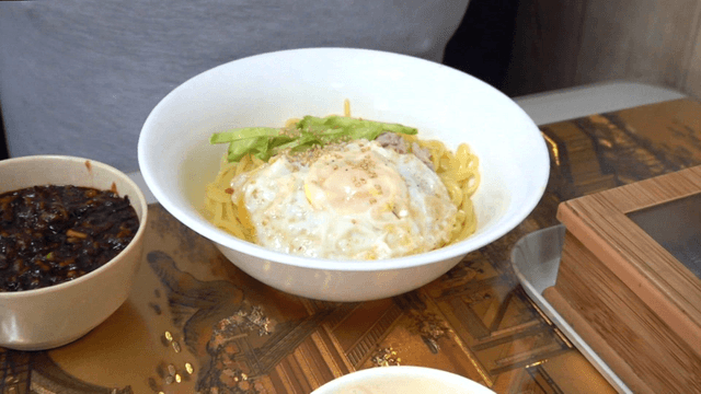 Noodles in thick black bean sauce topped with fried egg