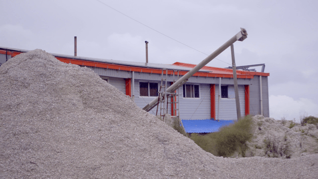 자갈 더미 위로 이어진 산업용 이송 파이프 설비