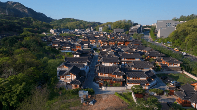 Traditional Korean hanok village with mountain backdrop