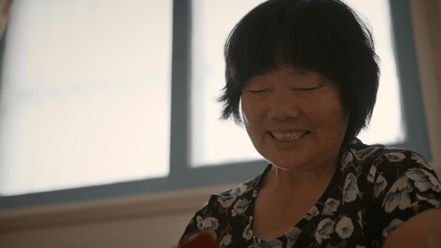 An elderly woman smiling indoors