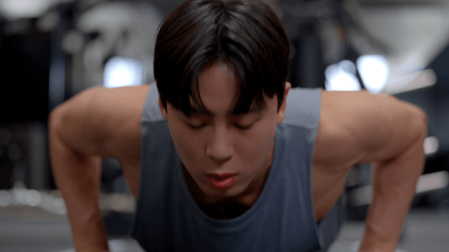 Young man doing push-ups in gym