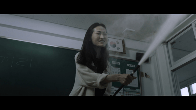 Woman angrily using fire extinguisher in classroom