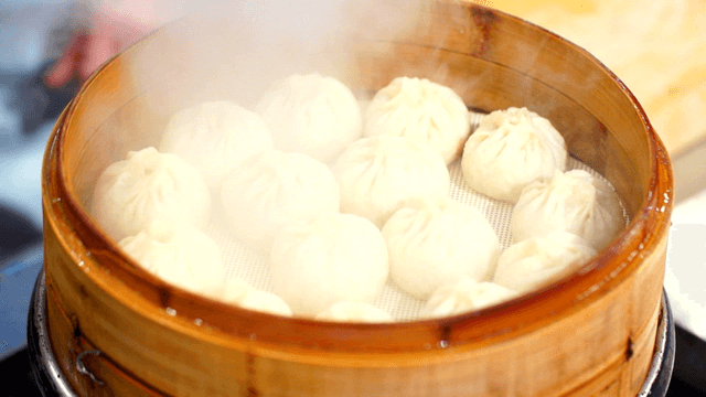 Dumplings steaming in a bamboo steamer