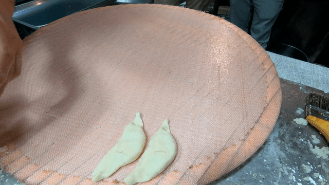 Hand arranging dumplings neatly on a large tray