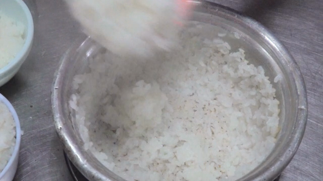 Steamed rice being served from a pot