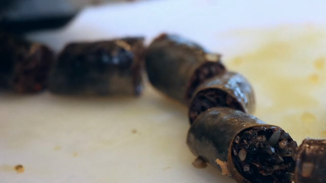 Korean sausage being sliced on a board