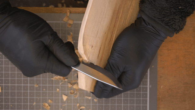 Woodcraft artisan carving wood precisely with a knife