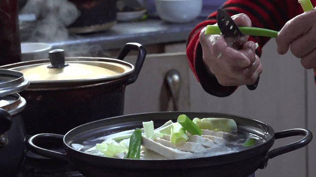 Grandmother slicing green onions in a cozy kitchen