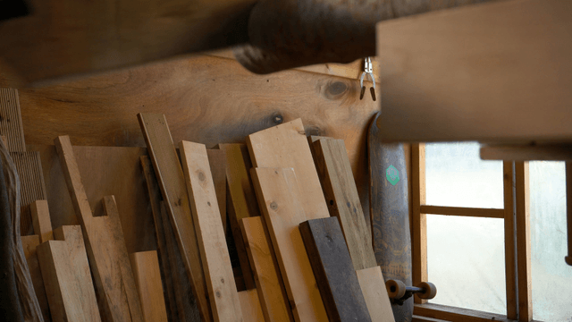 Hands sawing a wooden log with a saw