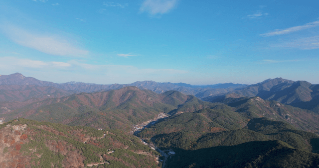 Expansive autumn mountain range under a clear sky