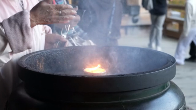 People praying with incense and candle