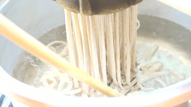 Scene of noodles coming out of a noodle making machine
