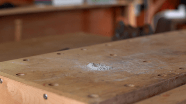 Dust being swept off a wooden table