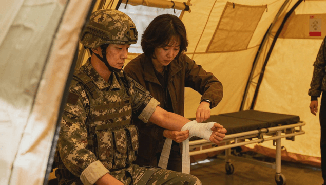 Soldier receiving medical treatment in a tent