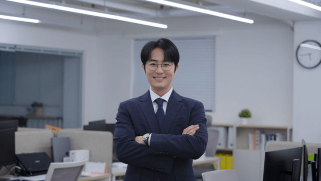 사무실에서 팔짱 끼며 미소 짓는 직장인