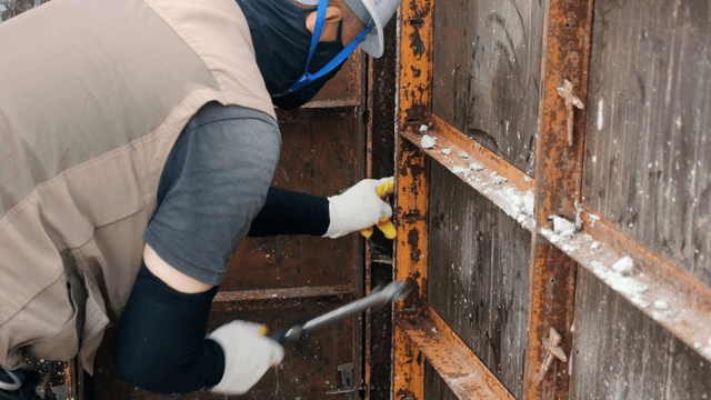 Worker using tools on a metal structure