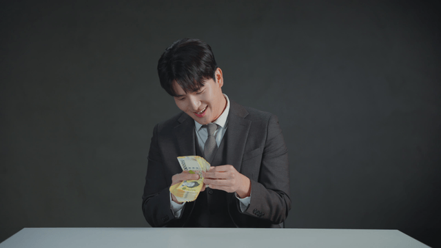 Man in a suit counting money with a satisfied expression