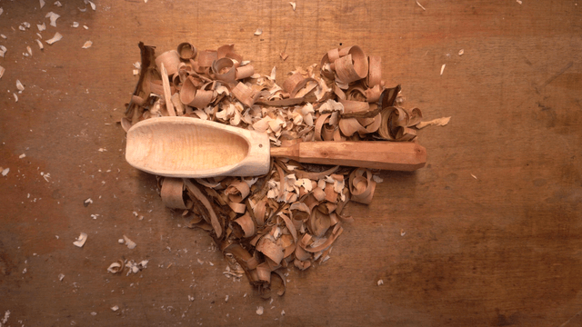 Carved wooden scoop on wood shavings