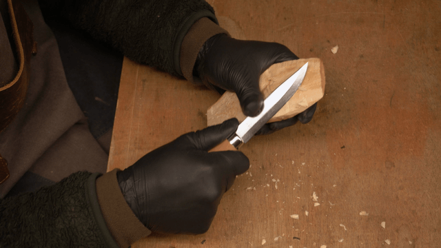 Woodcraft artisan carving wood with a knife
