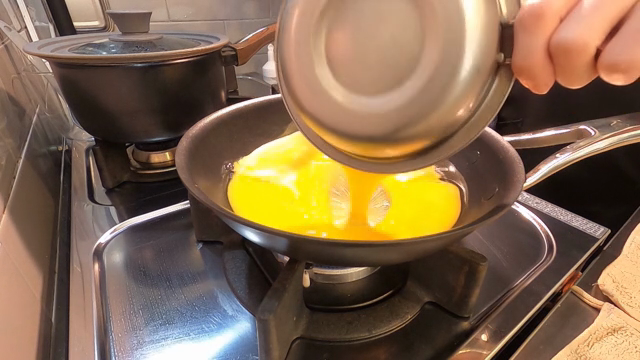Pouring beaten eggs into a frying pan