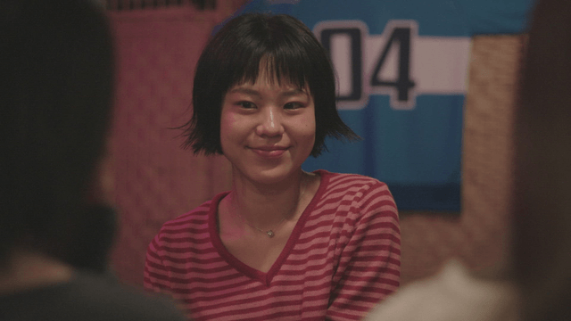 Woman in a striped shirt talking indoors