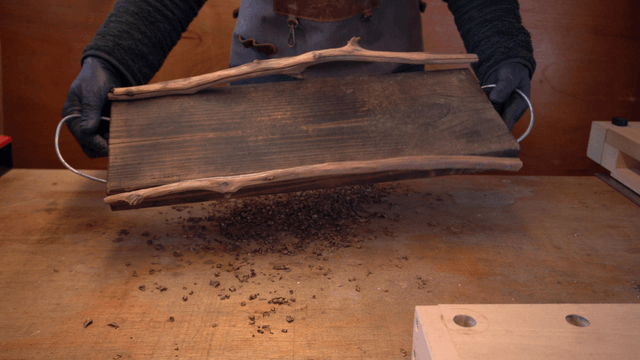 Person crafting with wooden tools indoors