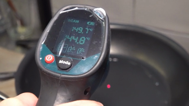 Checking pan temperature with a thermometer