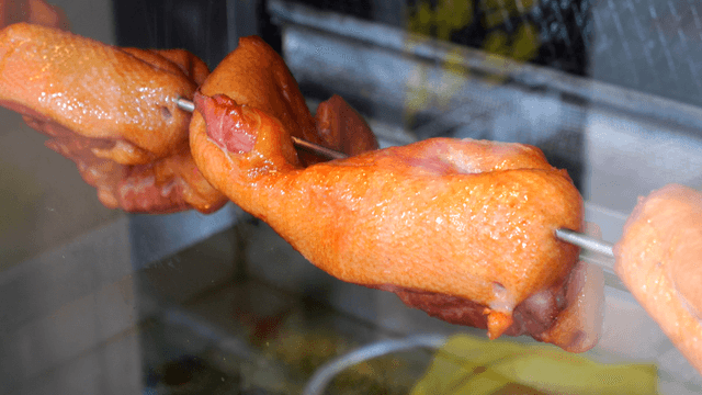 꼬치에 끼워져 기름이 떨어지는 전기구이 오리고기