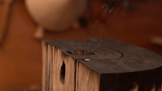 Smoke rising above the surface of a wooden sculpture