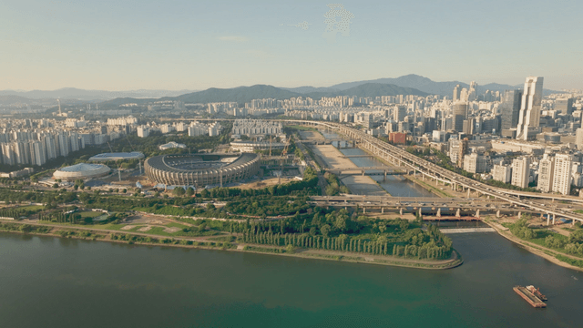 A sprawling cityscape with a stadium and river