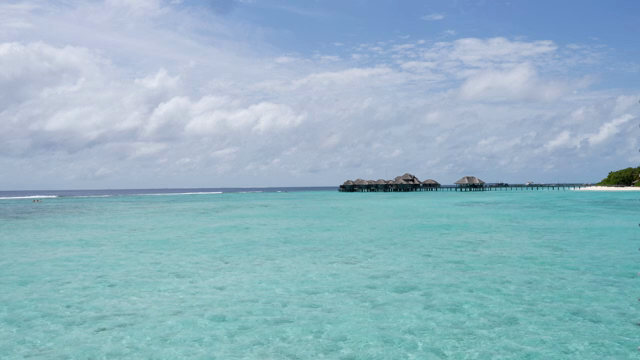 Clear turquoise sea with distant huts