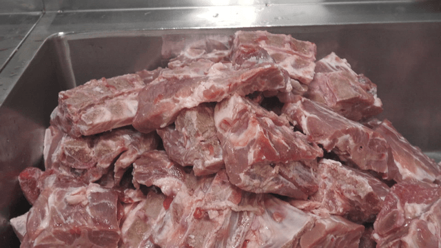 Pieces of raw meat stacked in a sink