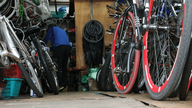 Person organizing bicycles in a shop